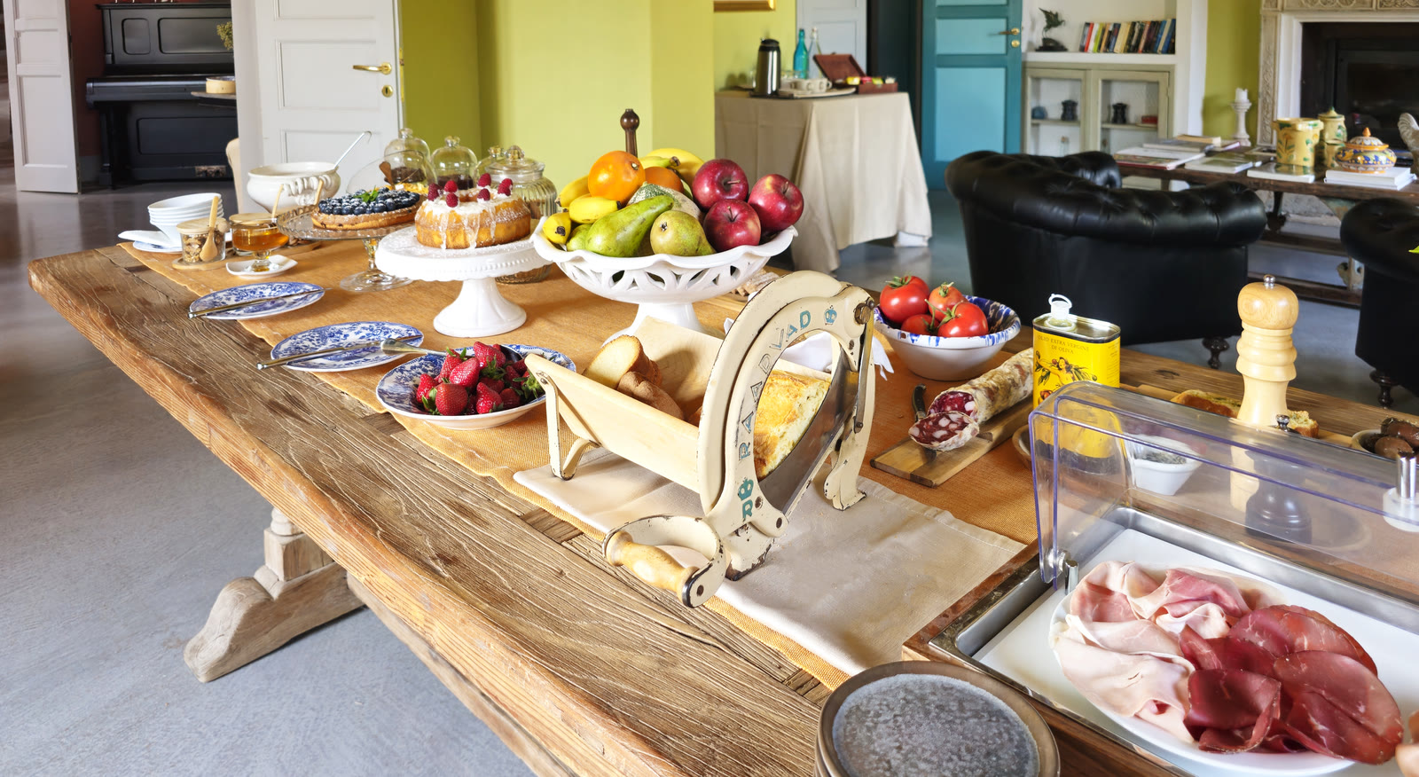 Il tavolo della colazione con pane, frutta, dolci e marmellate