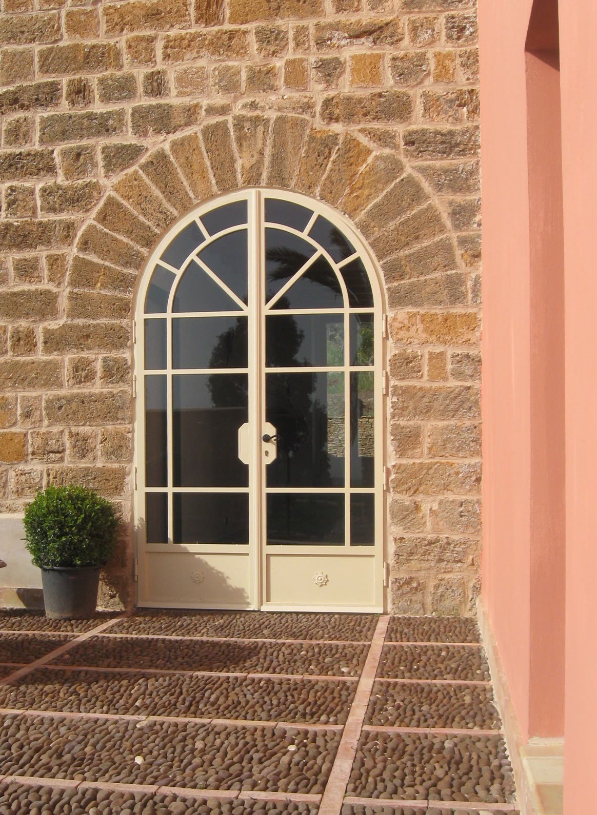 La porta ad arco in pietra della masseria, con il muro rosa