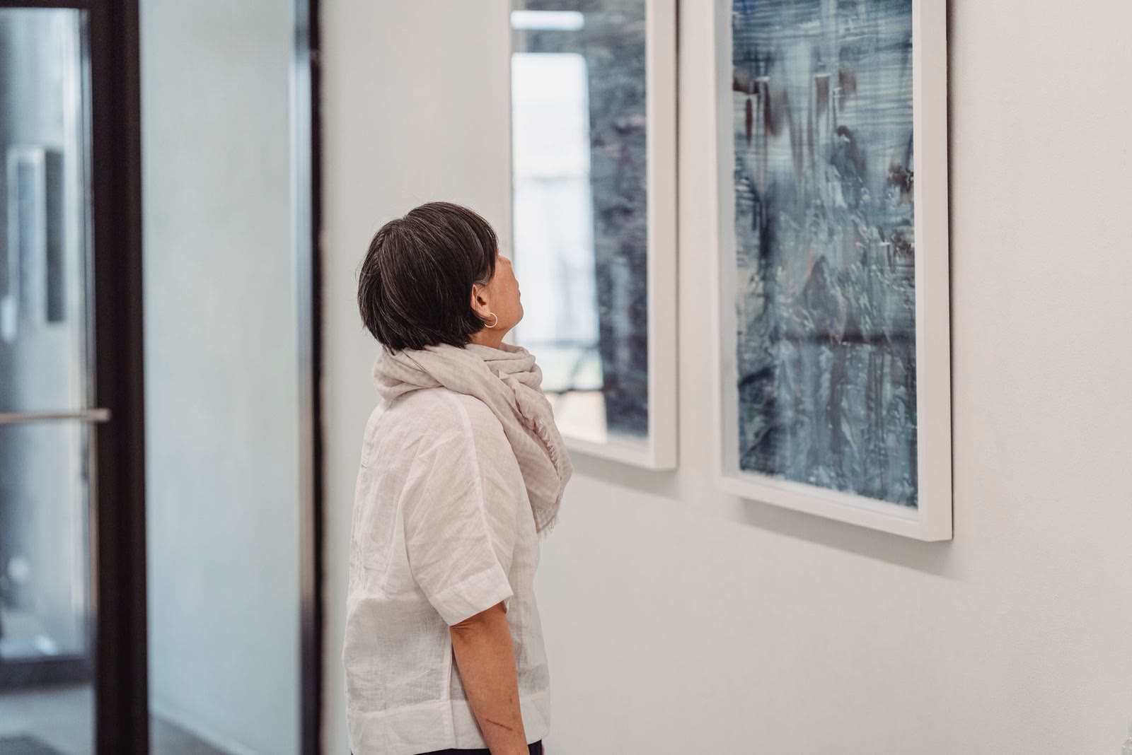 Una visitatrice guarda un quadro astratto in galleria